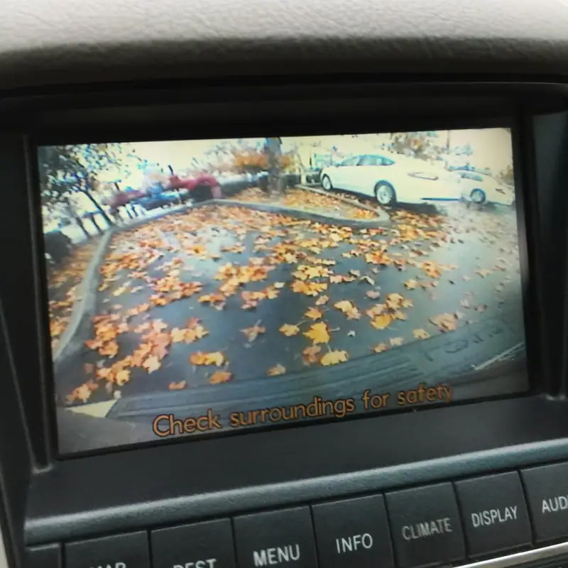 Navigation screen showing a rear camera view of a parking lot