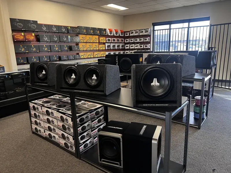Car audio showroom with JL Audio subwoofer enclosures and a speaker wall