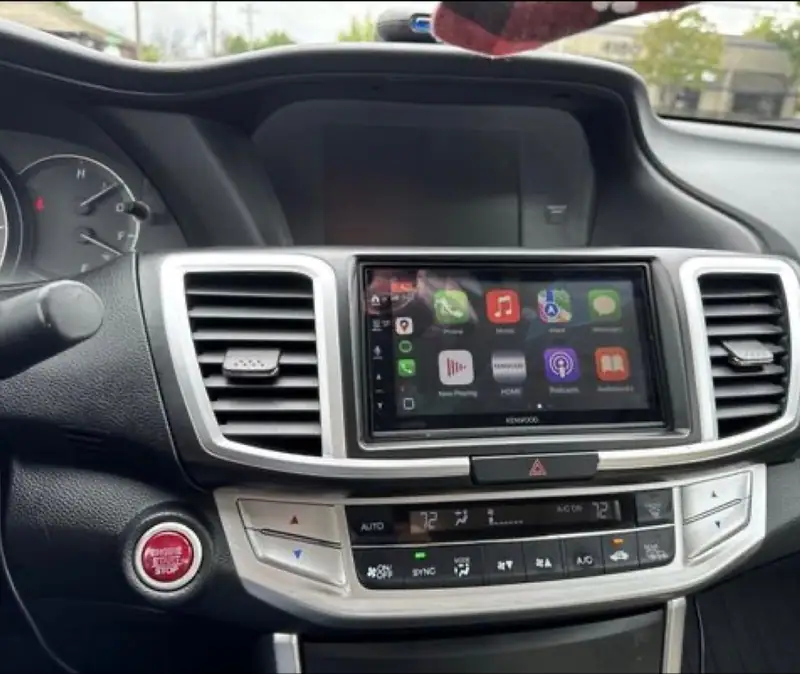 Kenwood touchscreen receiver showing Apple CarPlay in a car dashboard