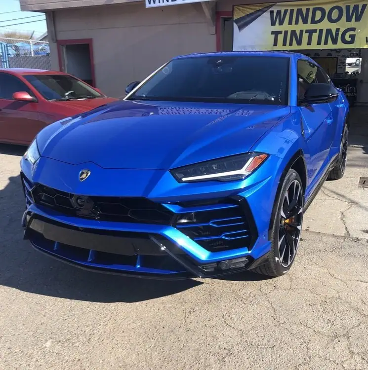 Blue Lamborghini Urus in front of the window tinting sign