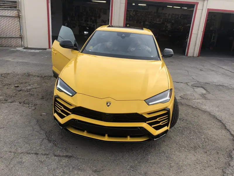 Yellow Lamborghini Urus parked at the shop