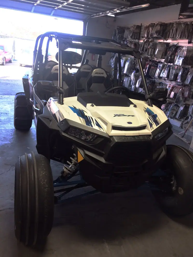 Polaris UTV in the bay with speaker pods on the cage