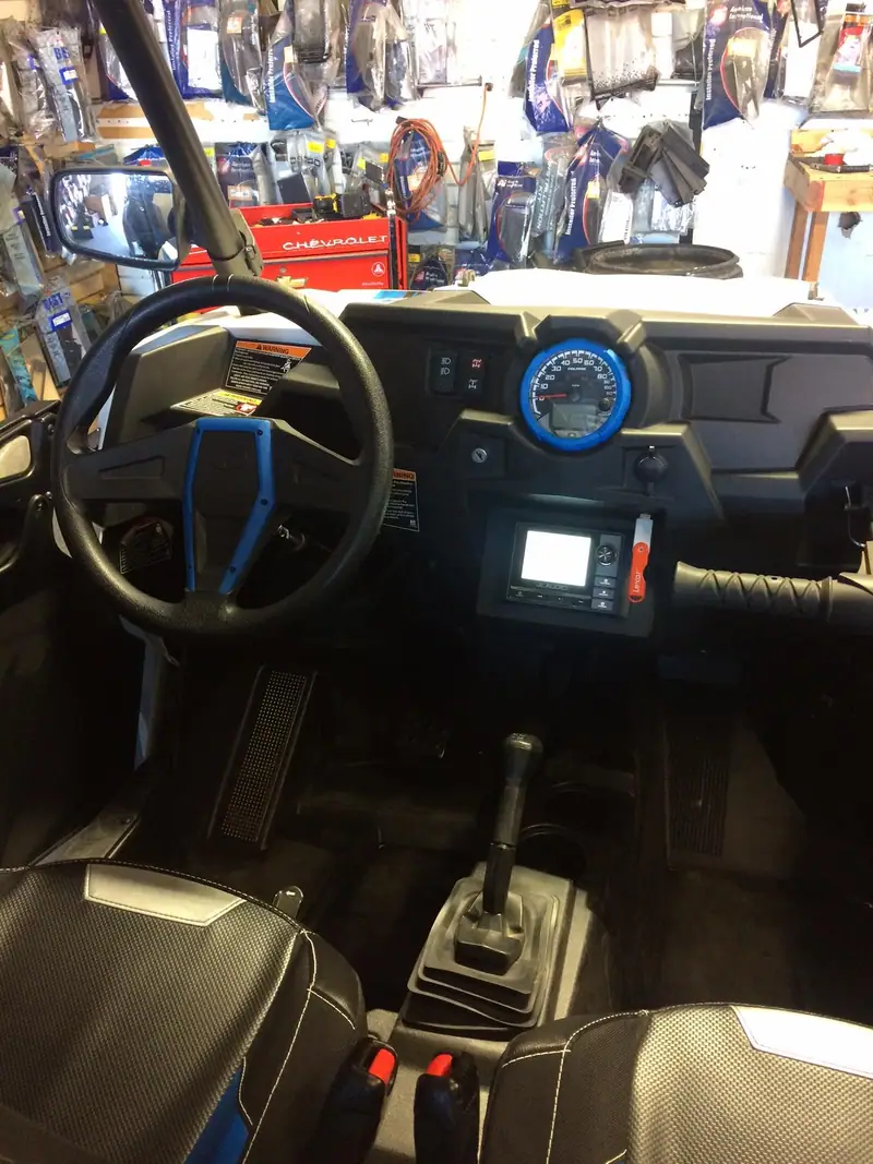 UTV dash with a stereo and blue-lit gauges